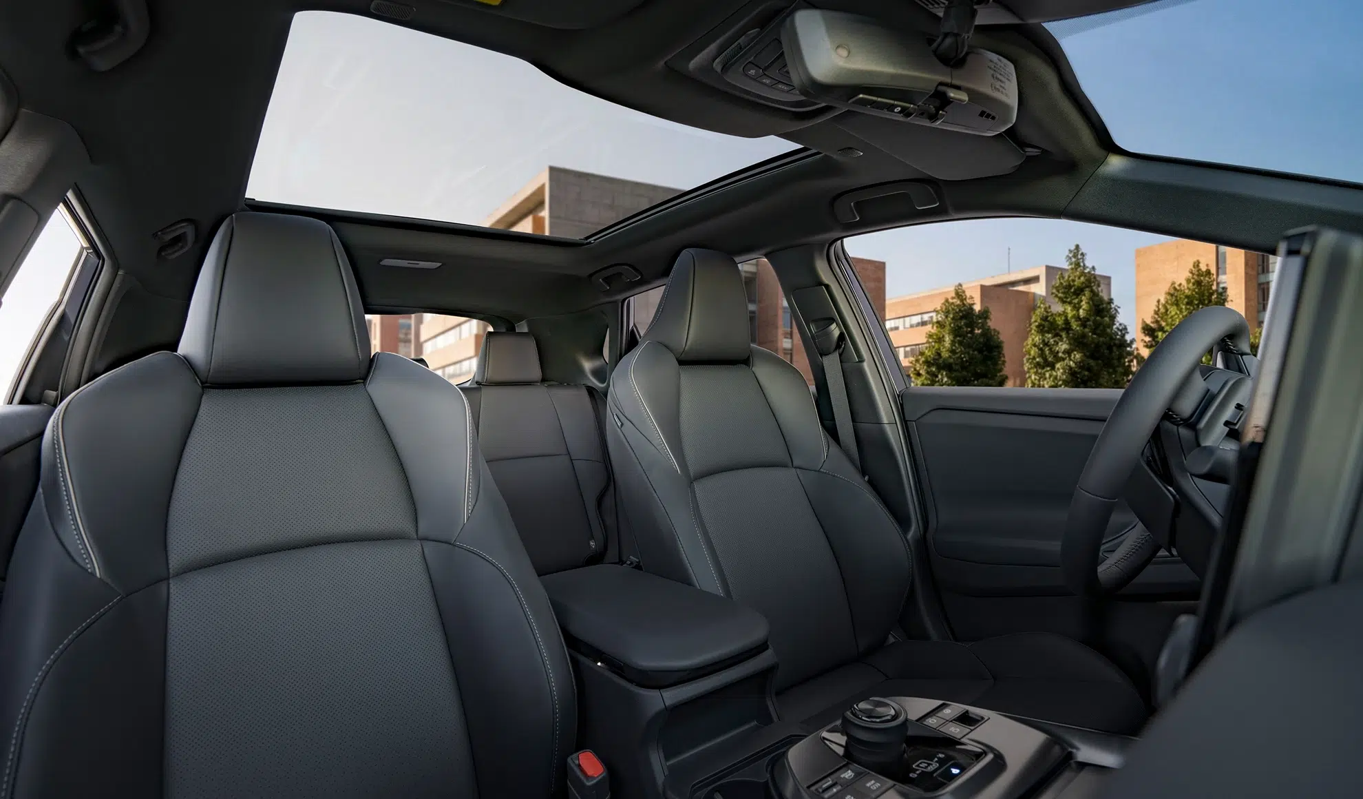 Interior of a modern car with black leather seats, panoramic sunroof, and center console controls visible