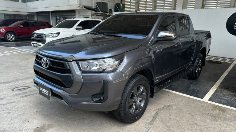 Front three-quarter view of a dark gray Toyota pickup truck with chrome grille in a dealership lot.