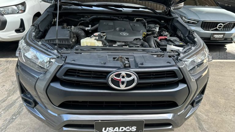 Gray Toyota SUV with hood open, exposing the engine bay and front grille in a dealership lot