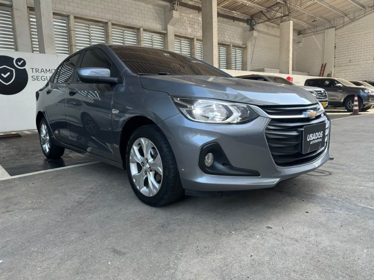 Gray Chevrolet sedan parked indoors at a dealership showroom, angled to show the front and side.