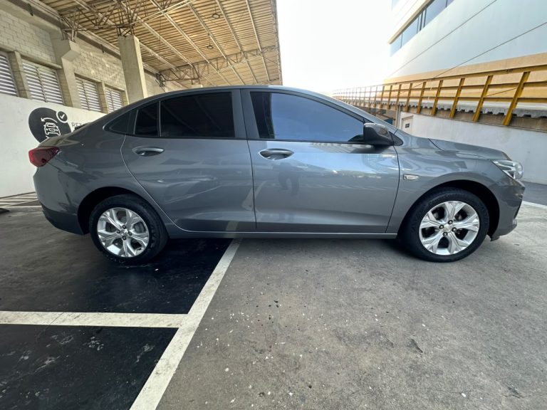 Gray sedan parked in a marked parking space under a covered area