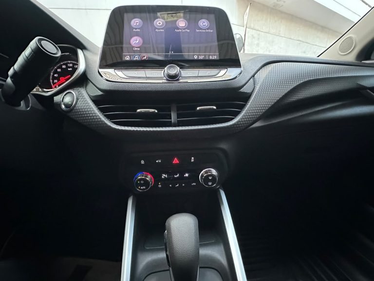Car interior focusing on a central touchscreen display above climate controls in a modern dashboard.